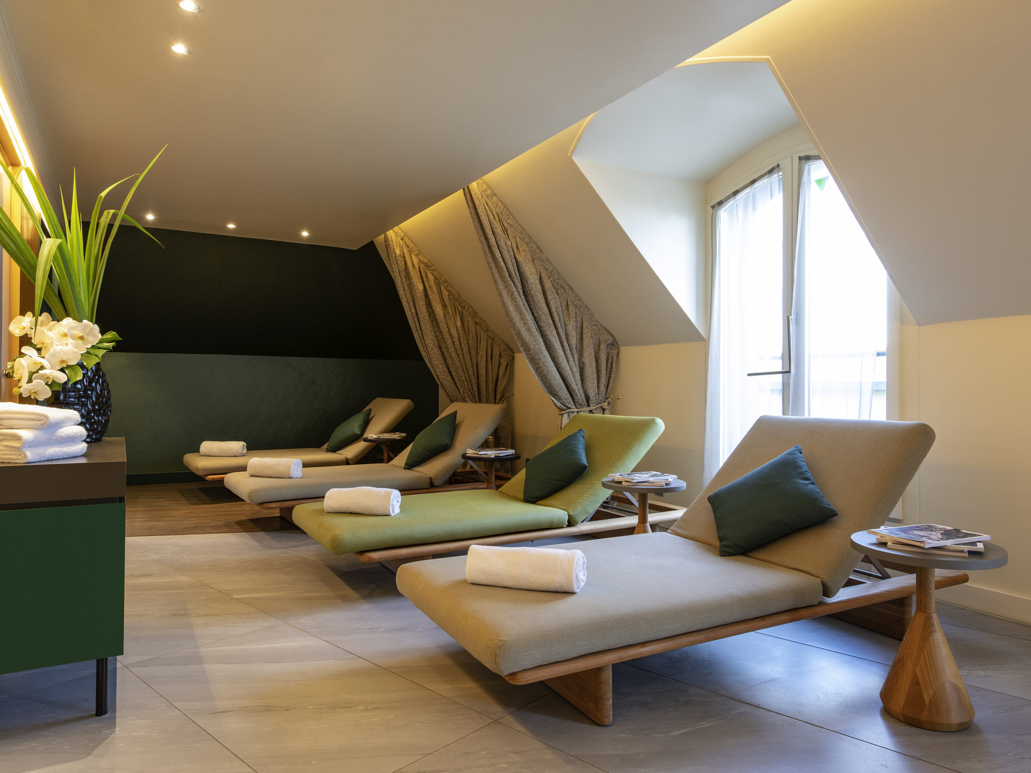 a room with lounge chairs and a plant