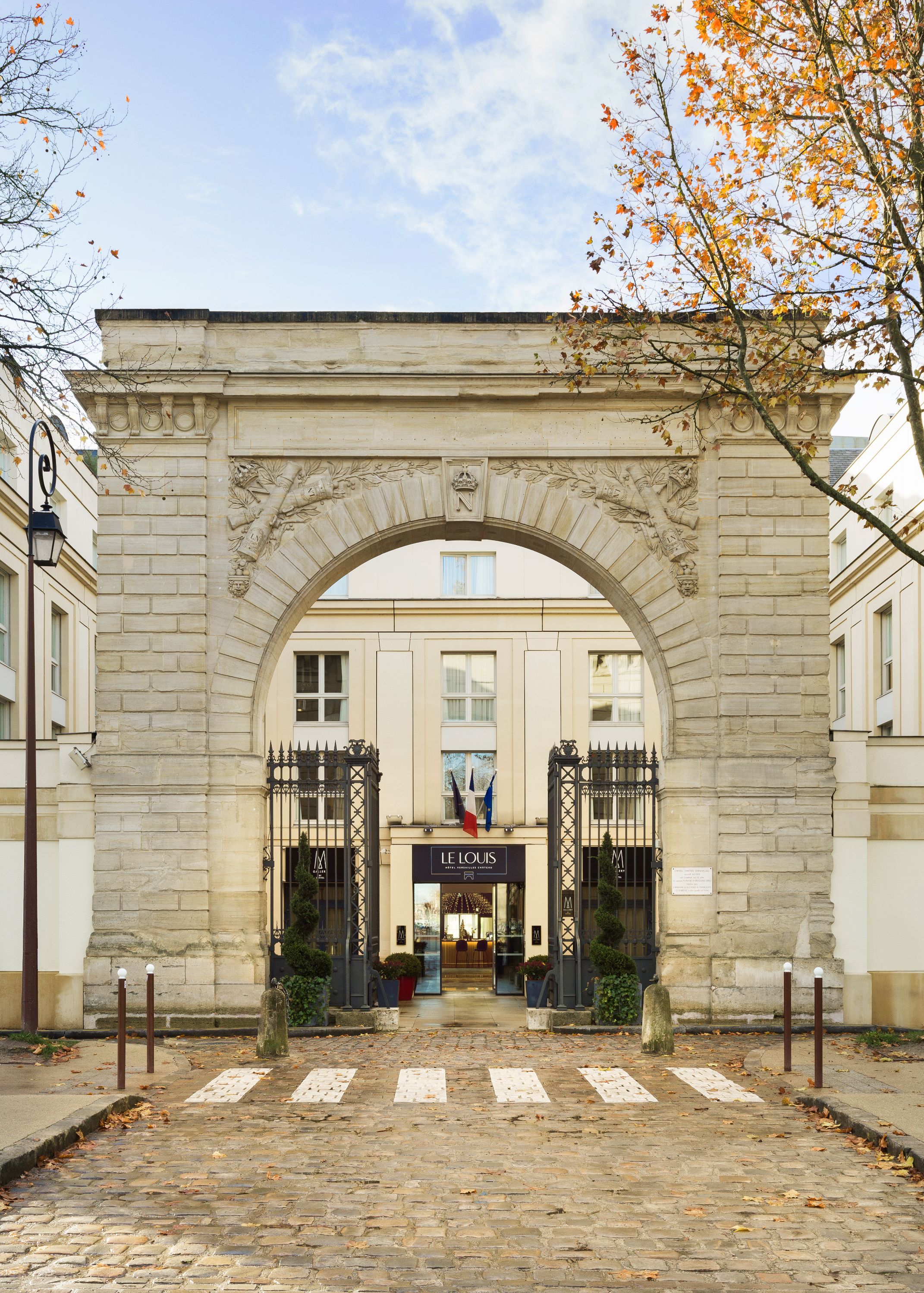 a stone archway with a gate and trees