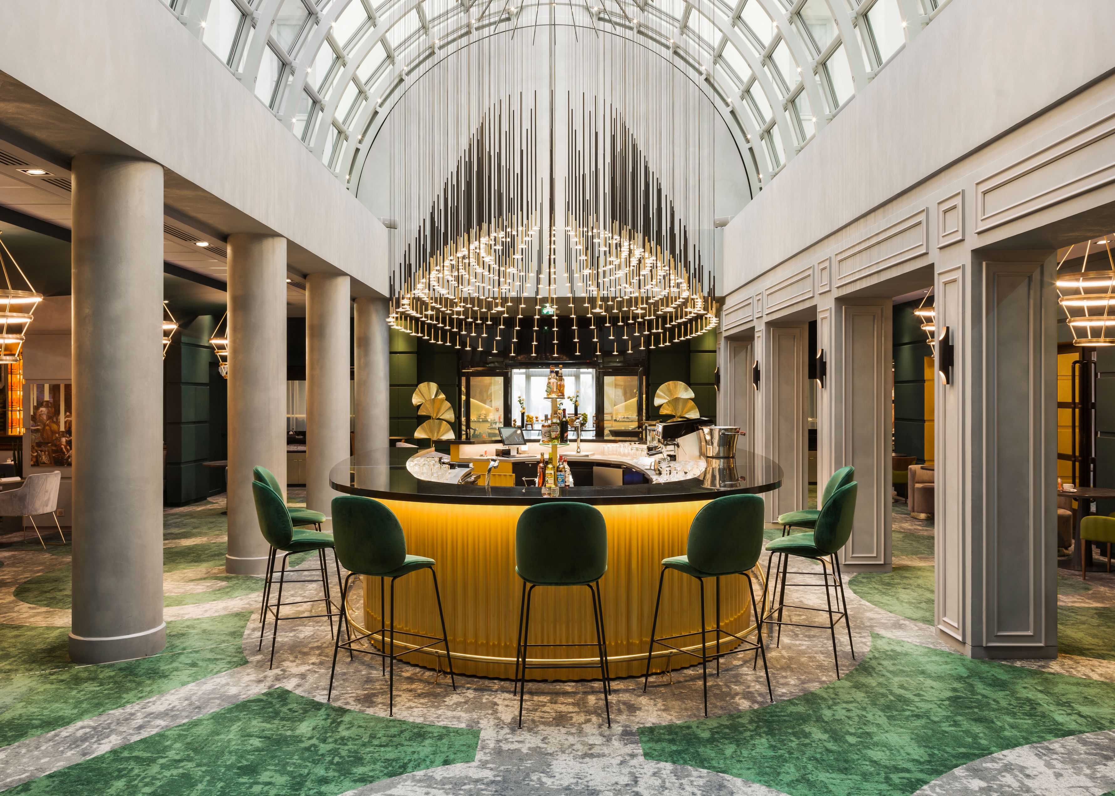 a bar with a round counter and chairs in a room with a ceiling and a glass dome