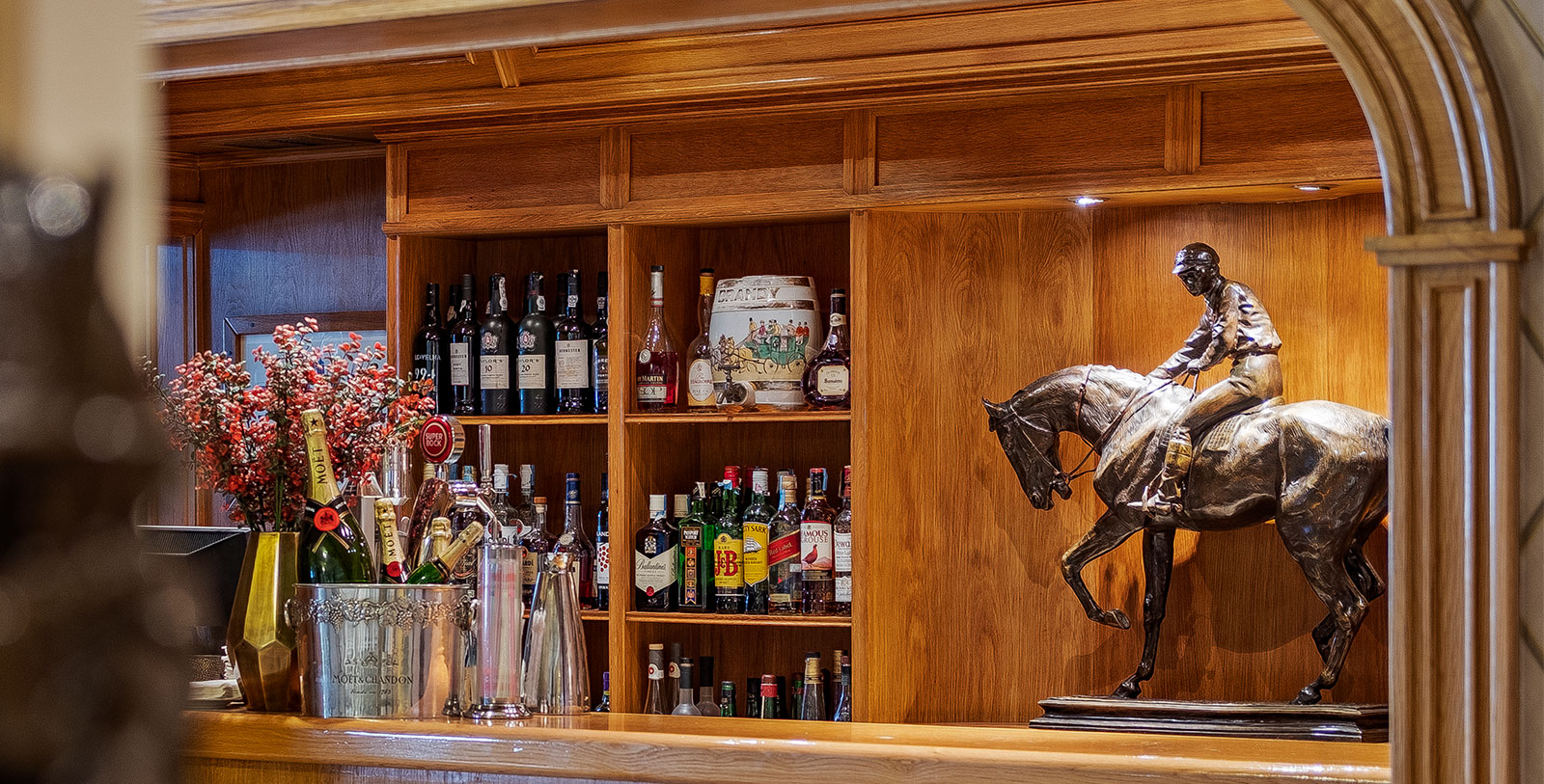 a bar with a statue of a horse and bottles of alcohol