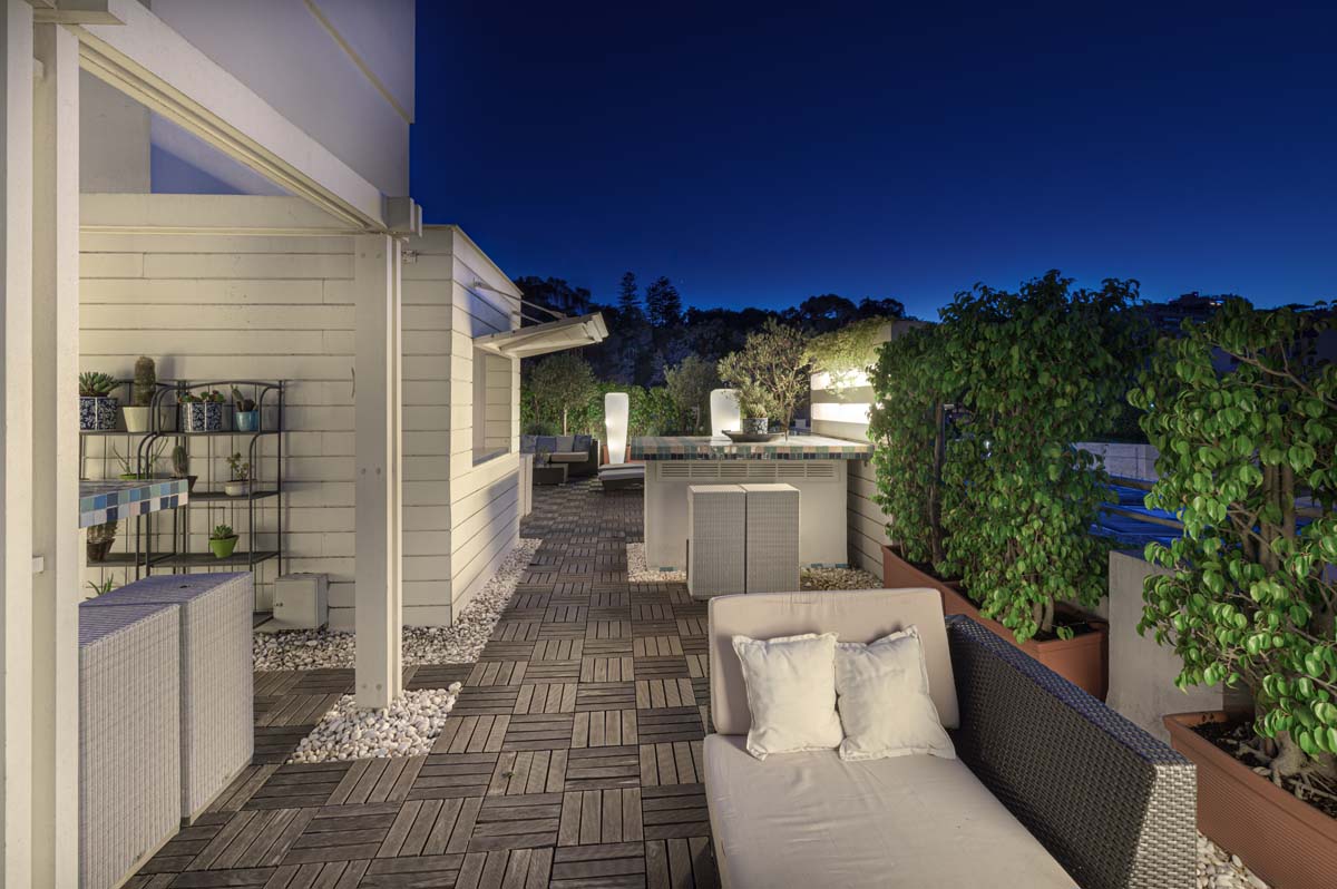 a patio with a couch and a table and a bar