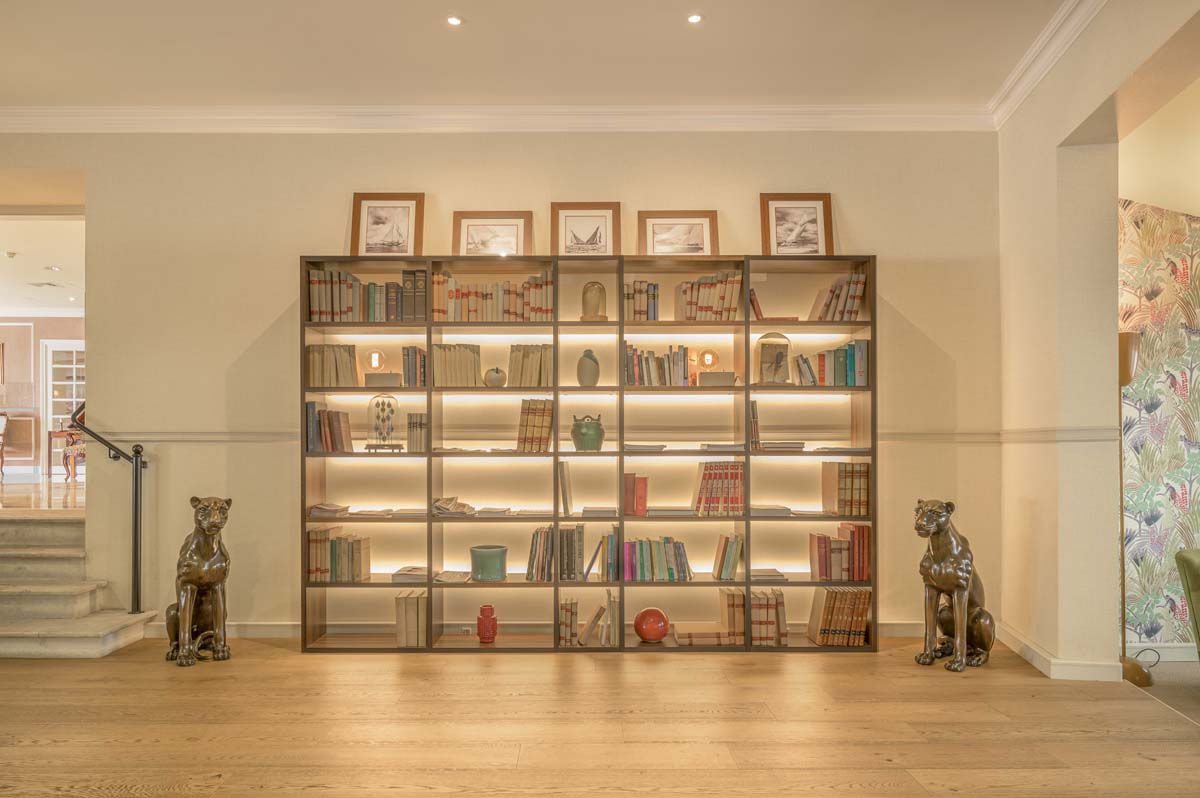 a bookcase with a couple of statues and pictures on it