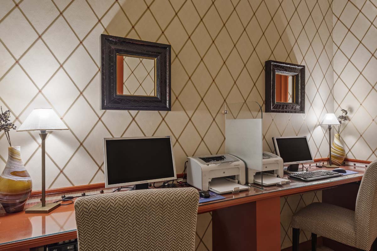a desk with computers and a printer