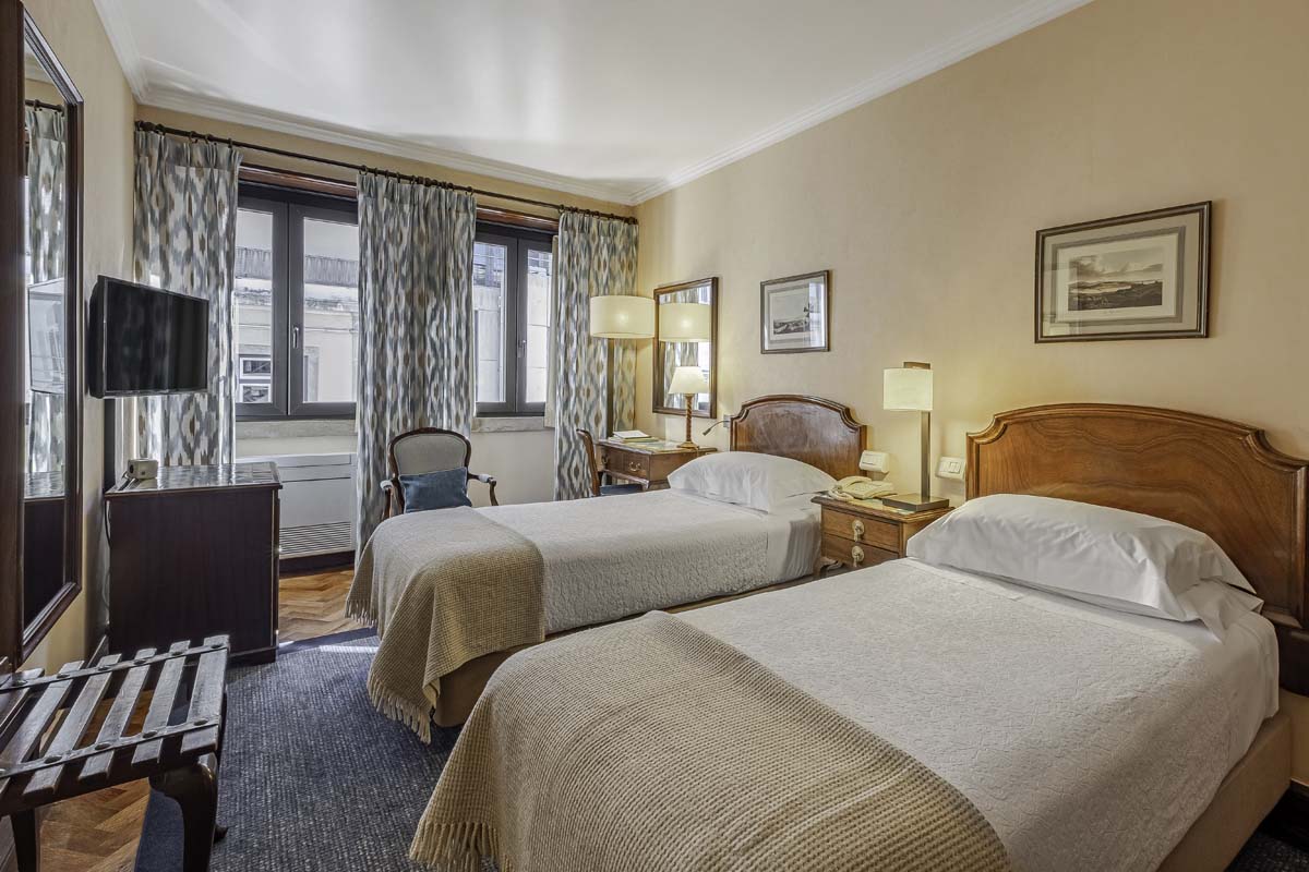 a room with two beds and a desk