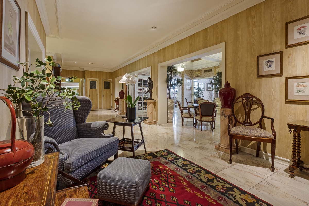 a living room with a large rug and chairs