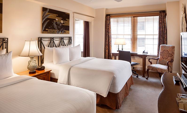a room with two beds and a desk