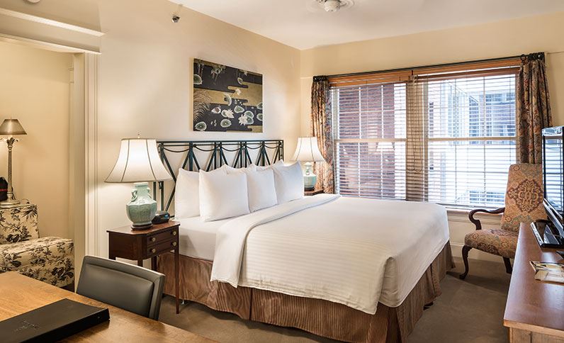 a bed with white sheets and lamps in a room