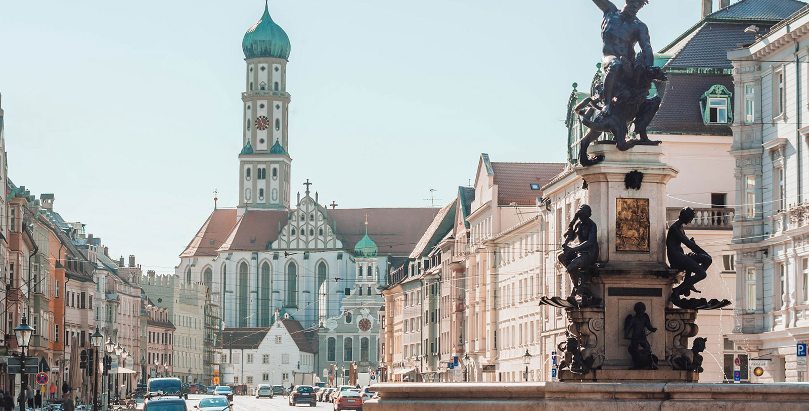 a street with a statue and a building in the background