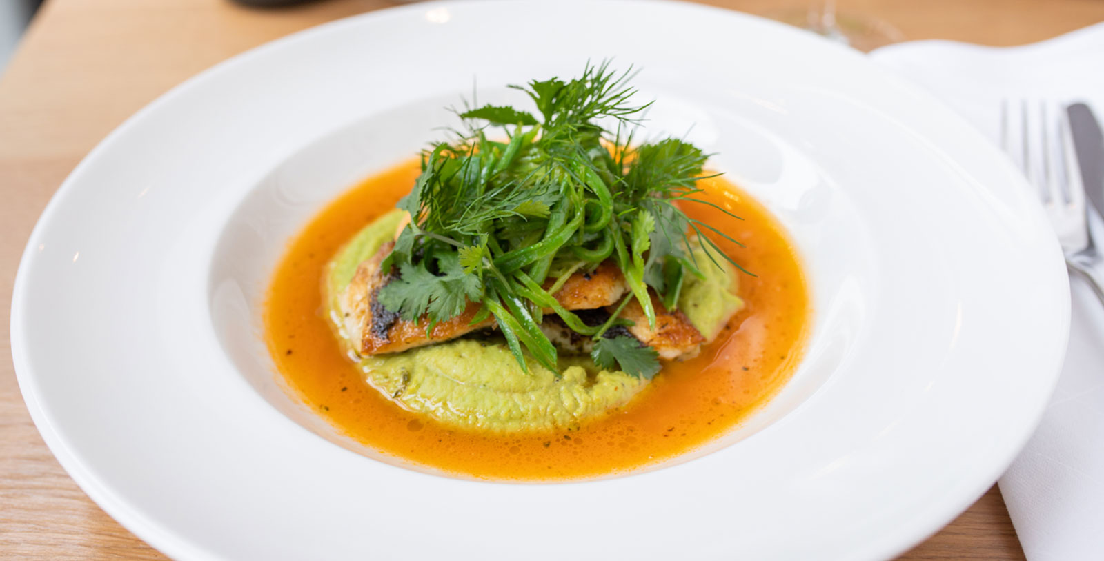 a plate of food with greens on top