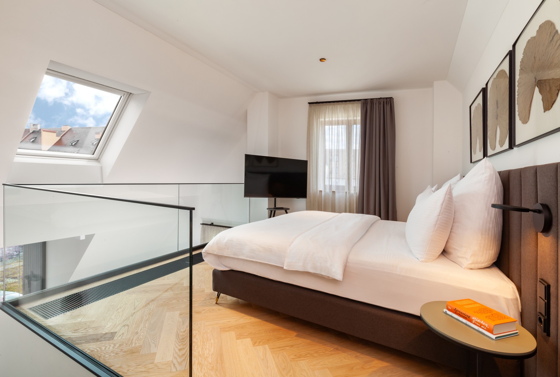 a bedroom with a glass railing and a bed