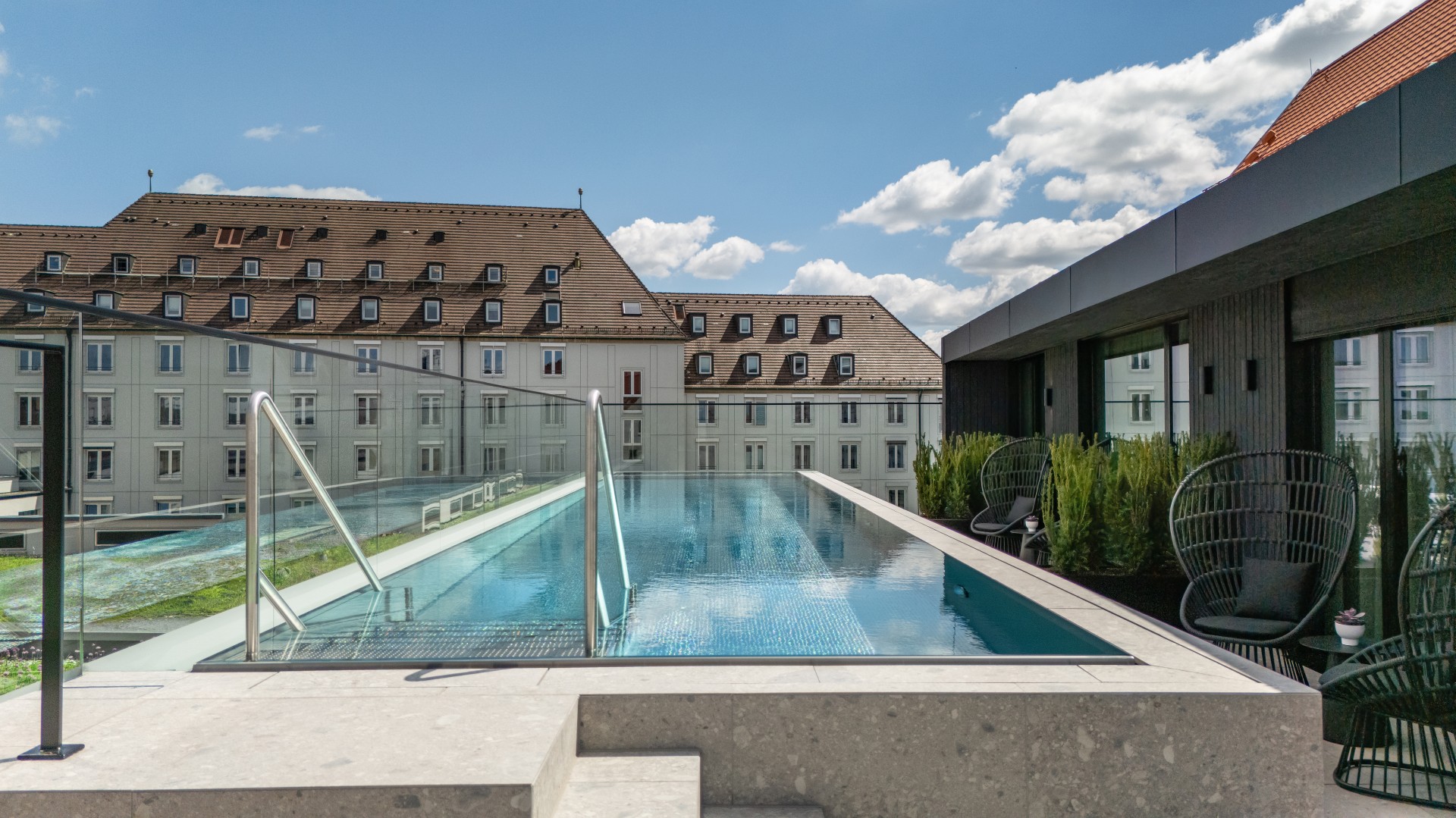 a pool with a railing and a building in the background