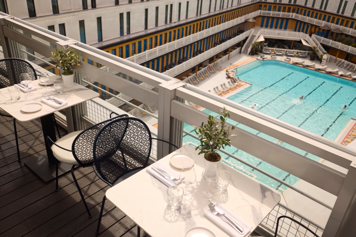 a table and chairs on a balcony overlooking a swimming pool