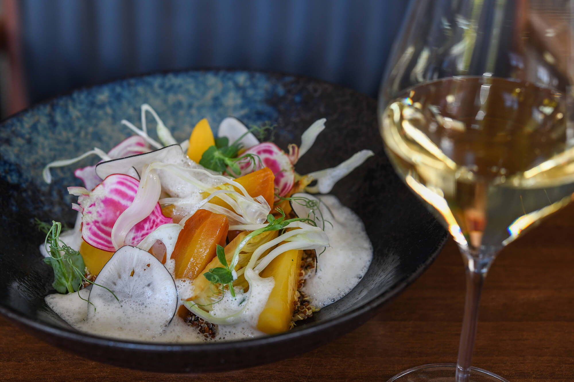 a bowl of food and a glass of wine