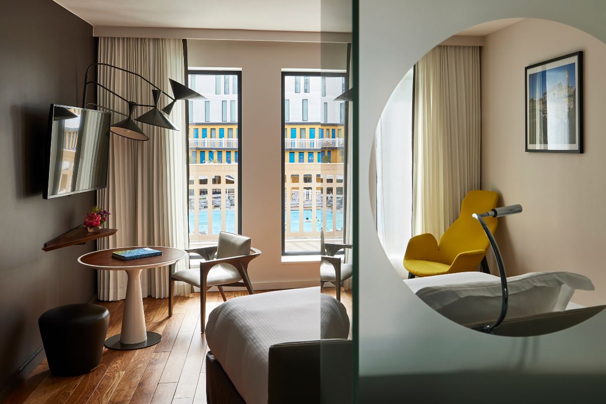 a room with a bed and chairs