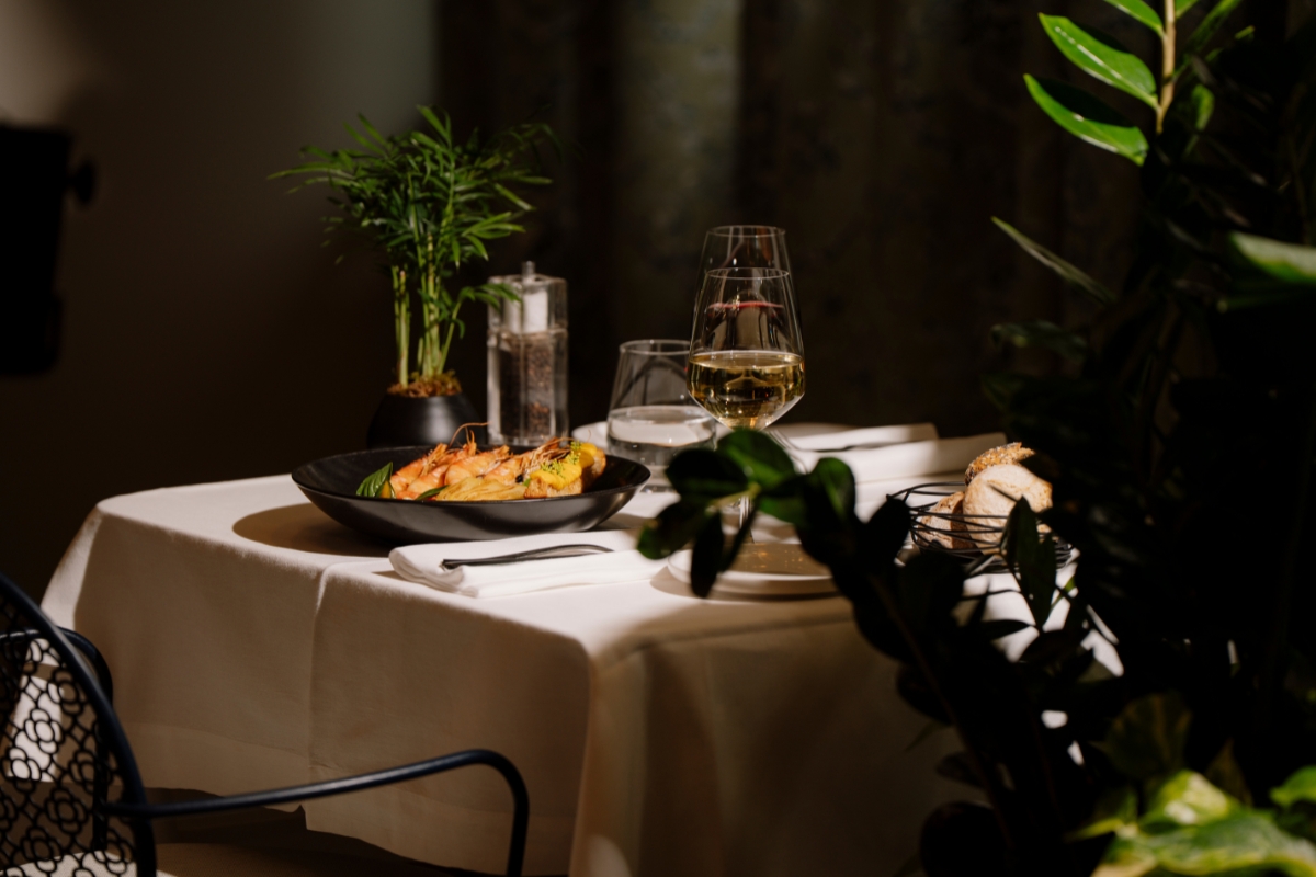 a table with a plate of food and glasses of wine