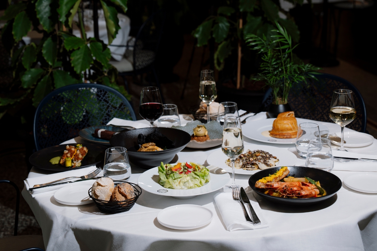 a table with plates of food and wine glasses