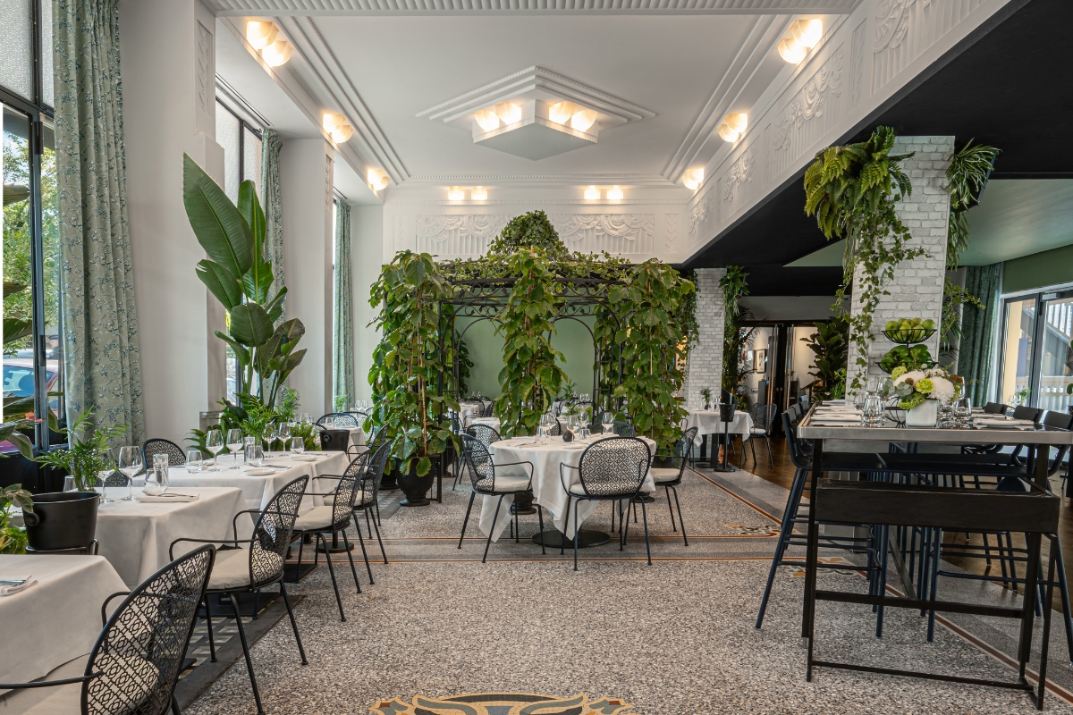 a room with tables and chairs and plants