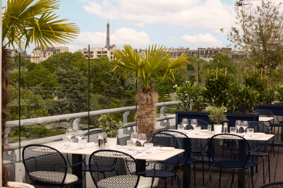a table set up on a balcony with trees and a tower in the background