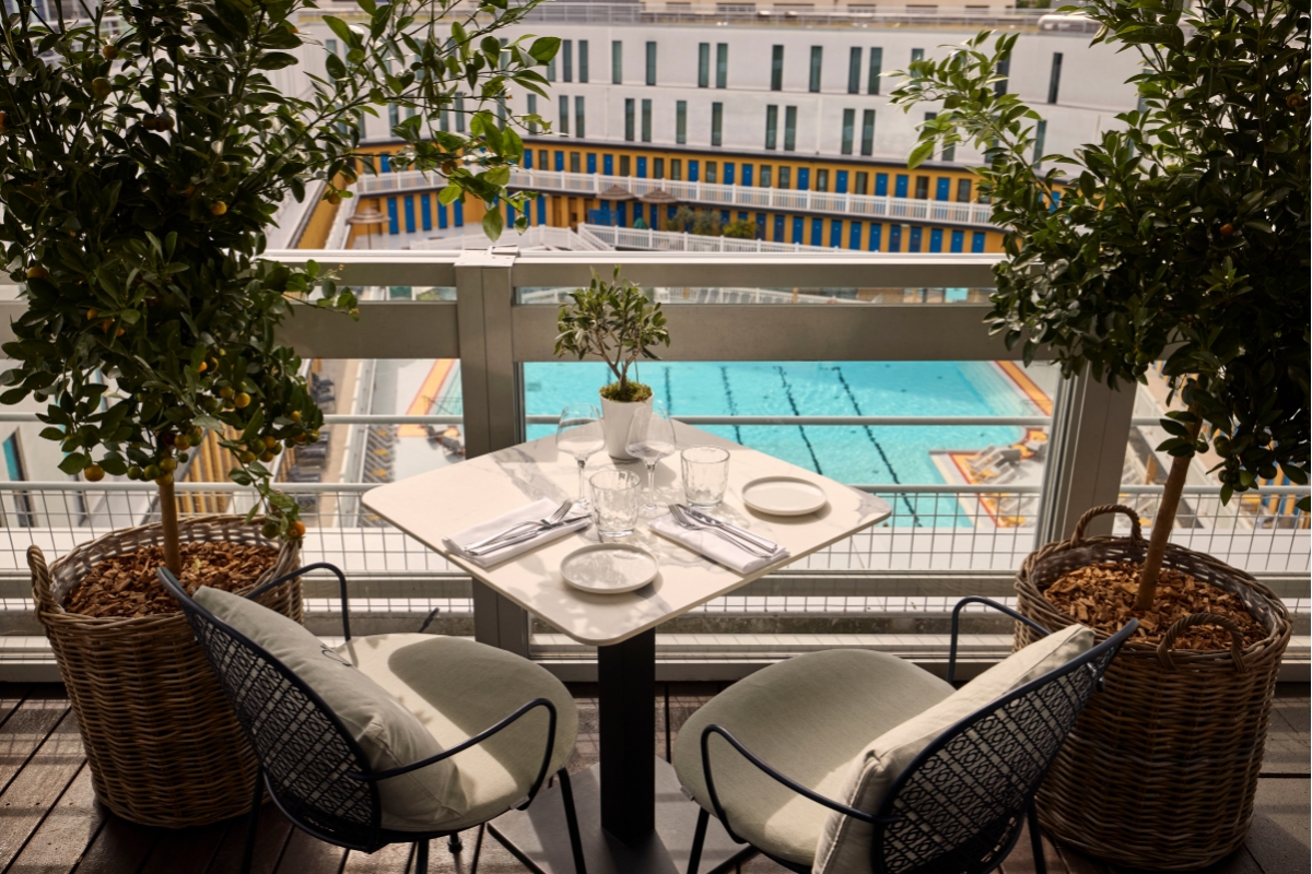 a table with chairs and a pool in the background