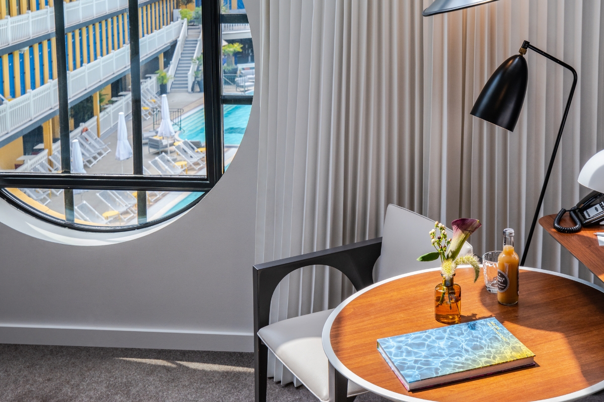 a table with a book and a lamp in a room with a pool