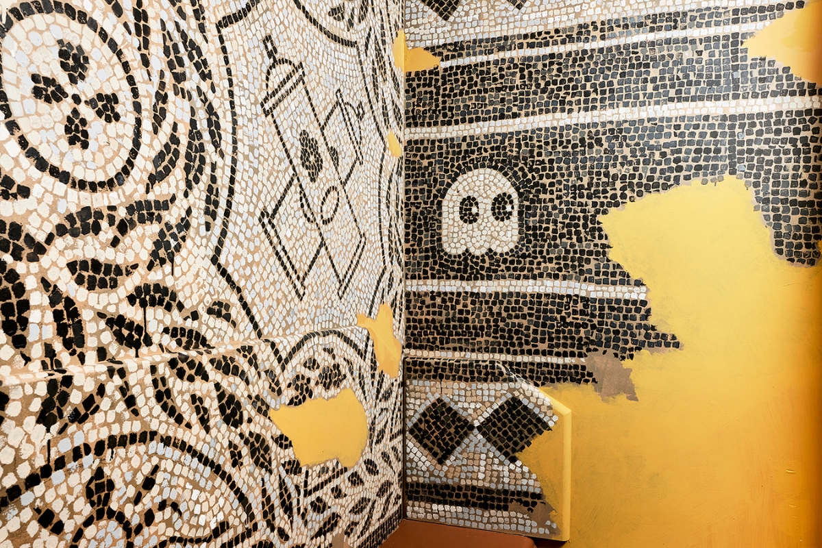 a mosaic wall with a skull and a spray can