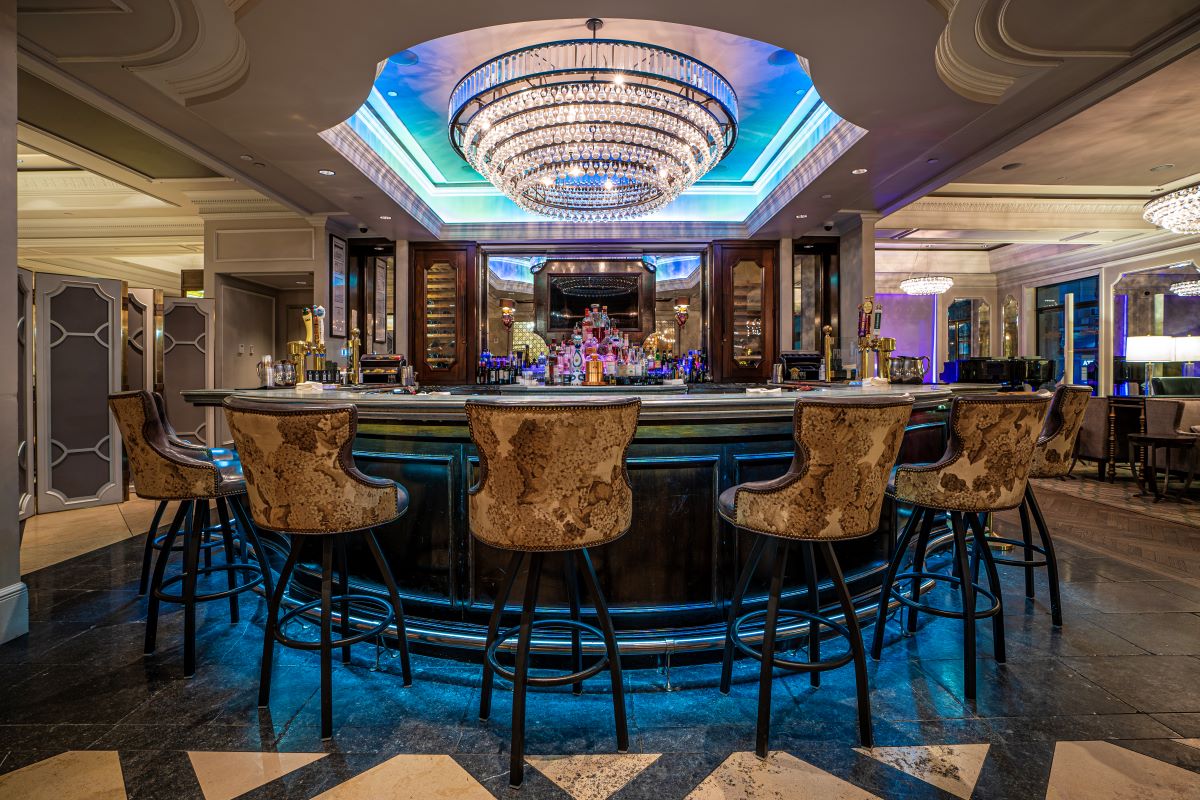 a bar with chairs and a chandelier