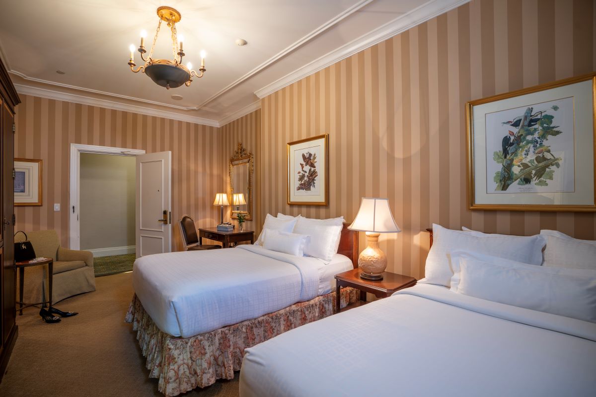 a room with two beds and a chandelier
