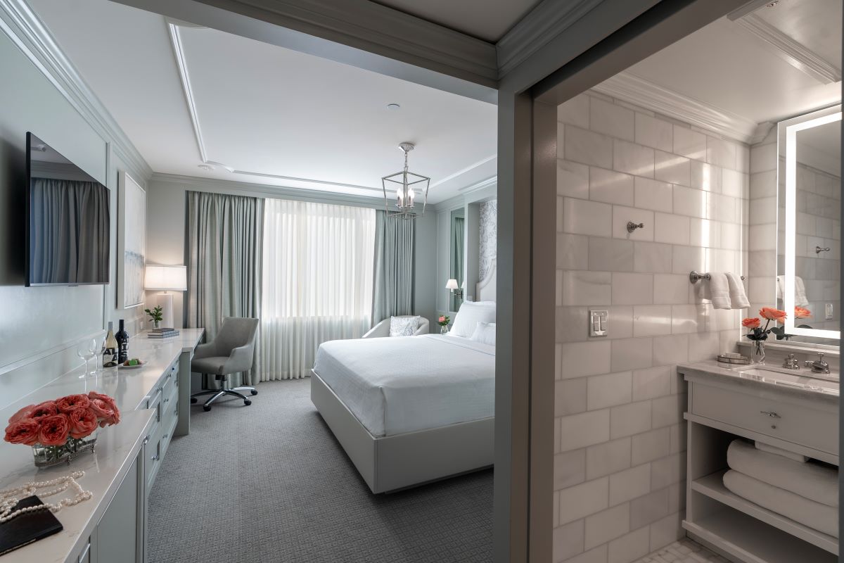 a bedroom with a white bed and a desk