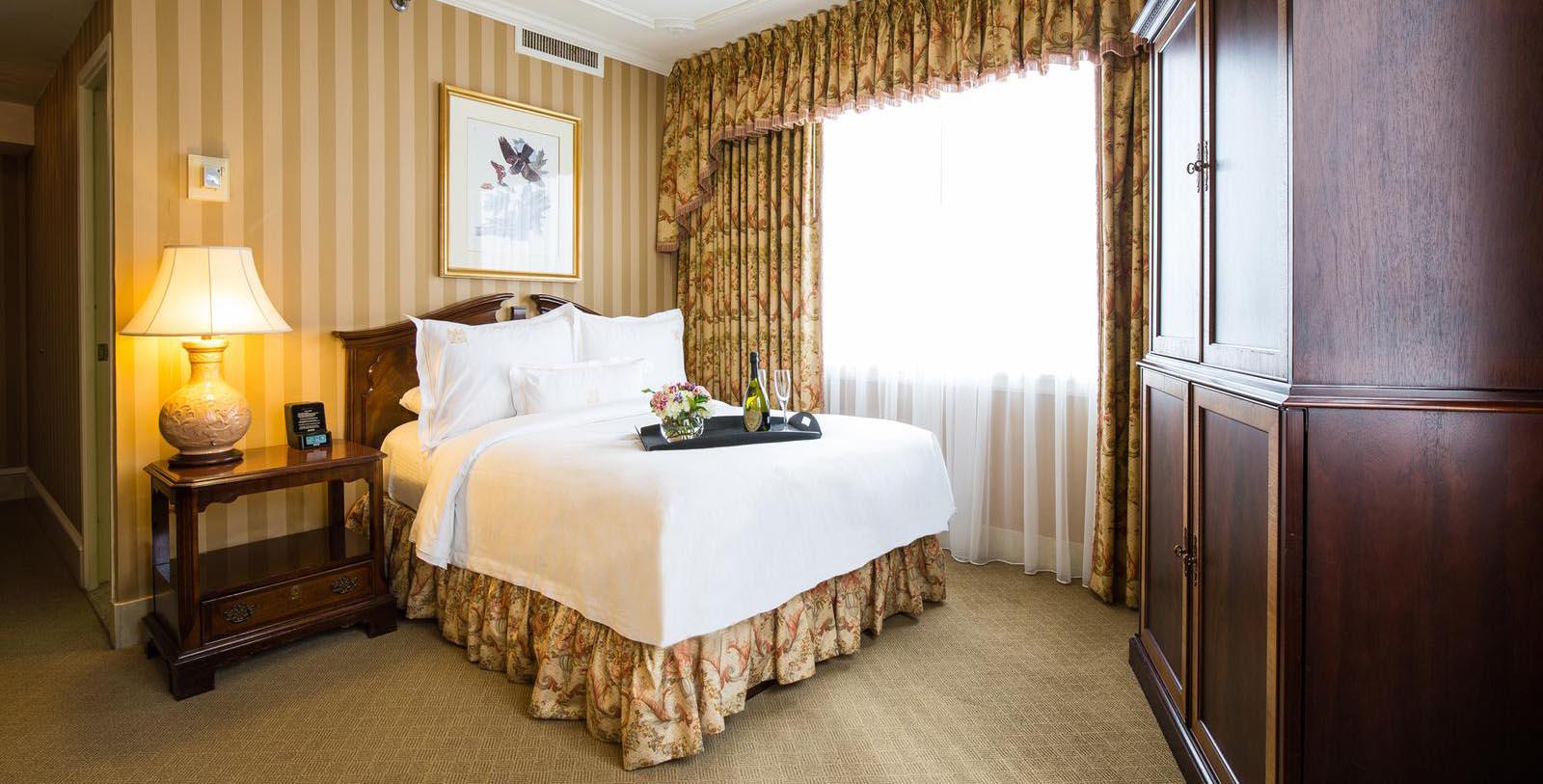 a bed with a tray of wine on it