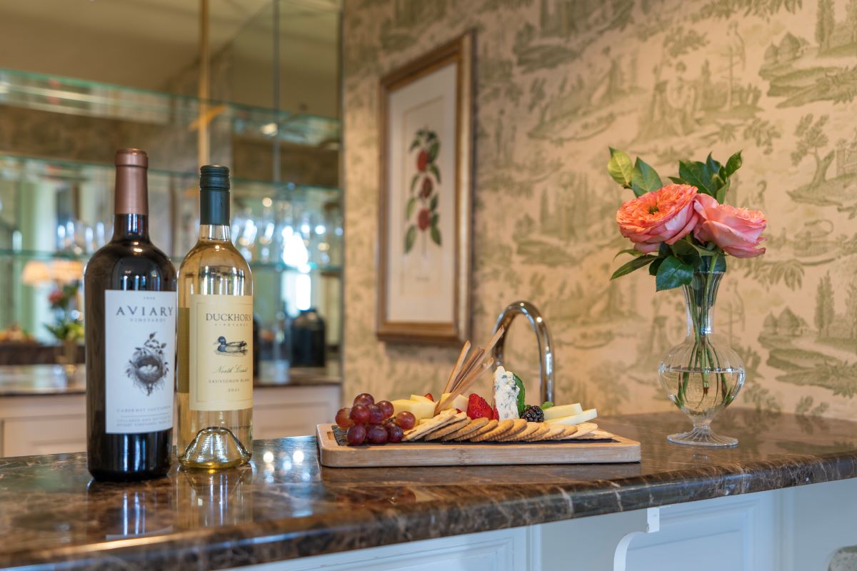 a wine bottles and a tray of food on a counter