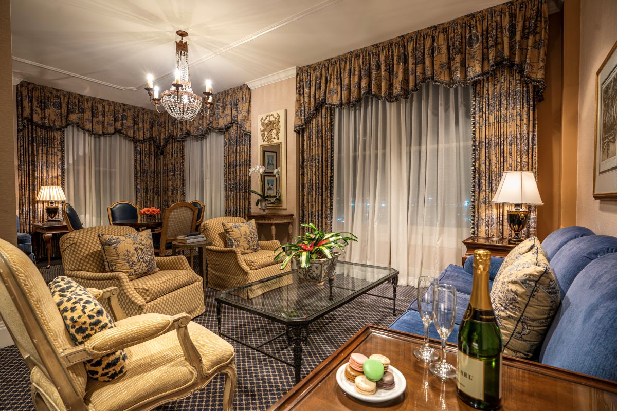 a living room with a glass coffee table and chairs