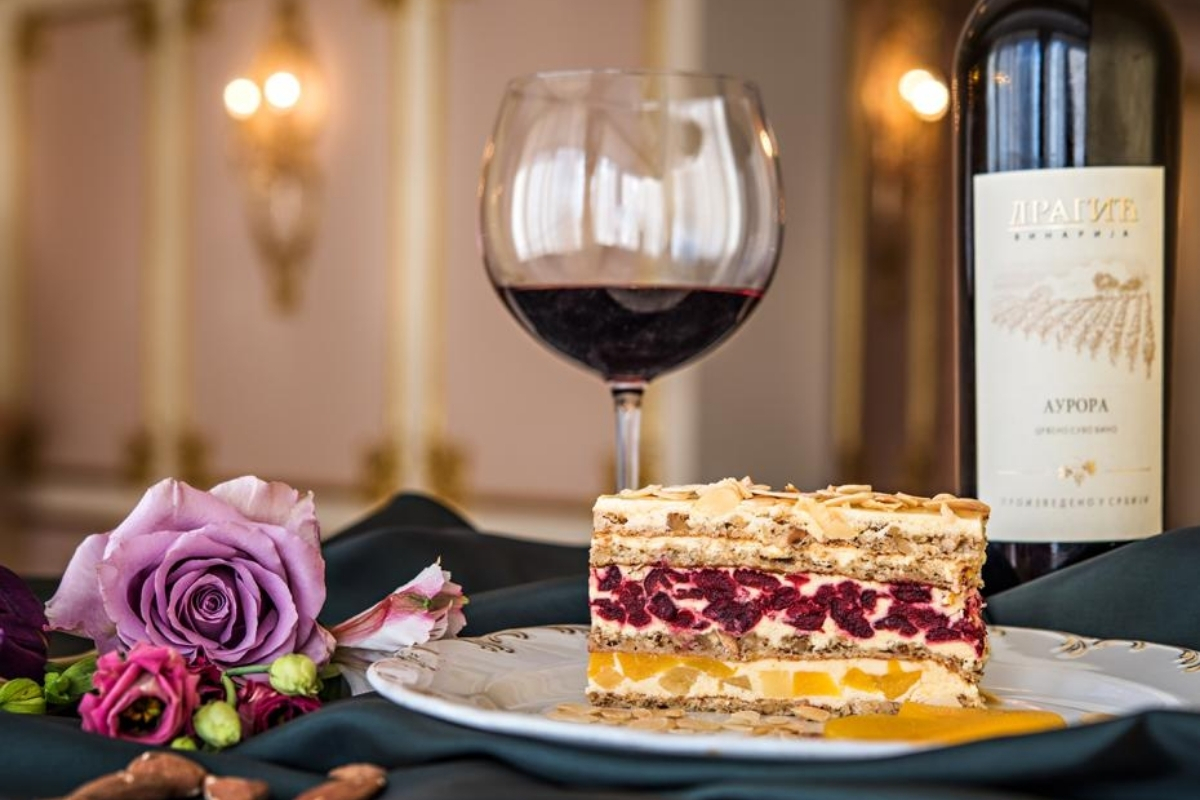 a slice of cake and a glass of wine