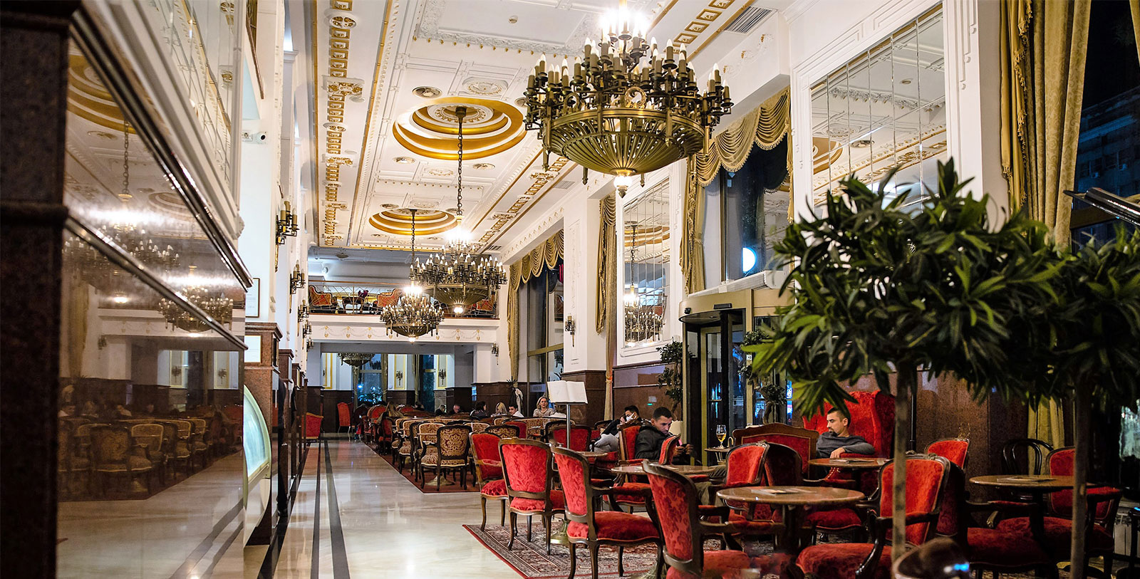 a room with tables and chairs and chandeliers