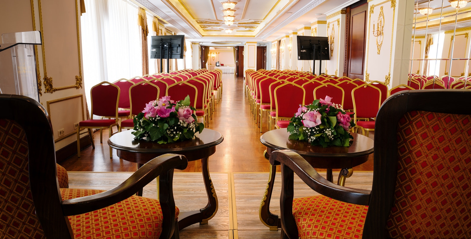 a room with chairs and tables with flowers