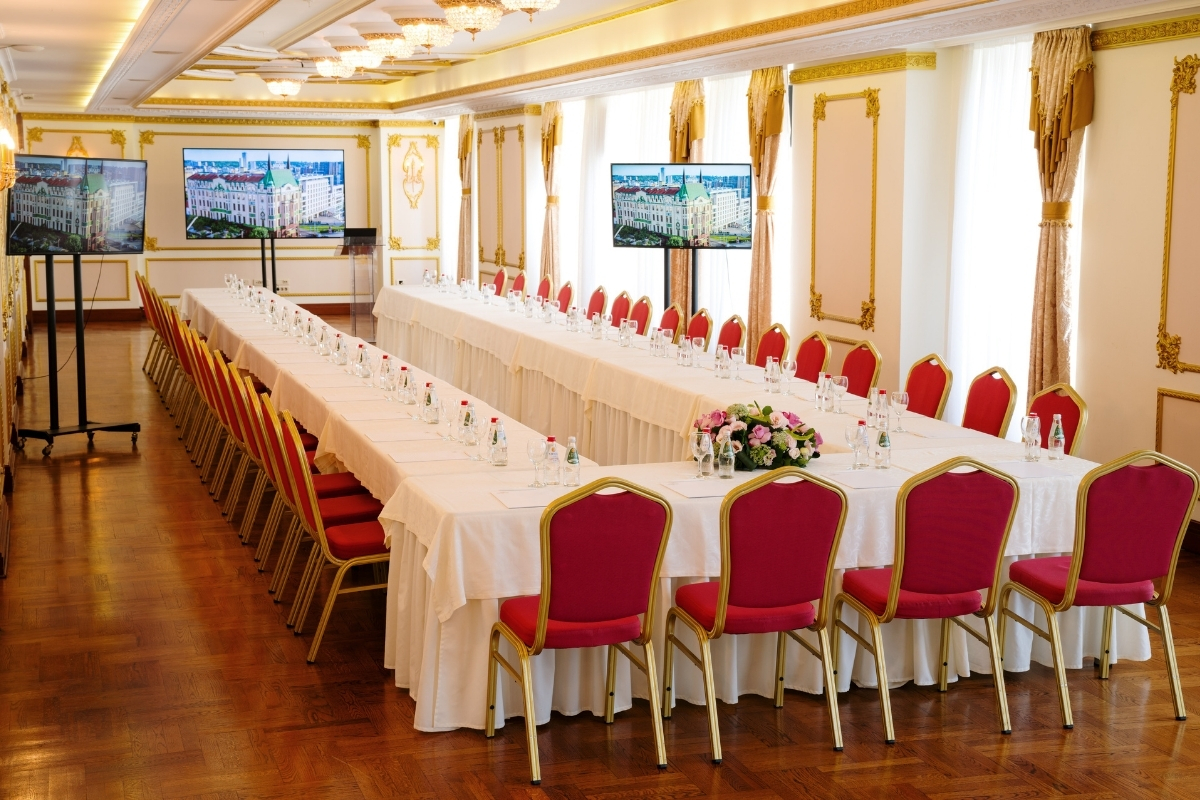 a long table with white tablecloths and red chairs