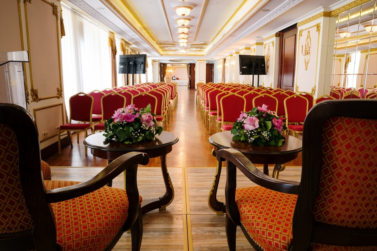 a room with chairs and tables with flowers