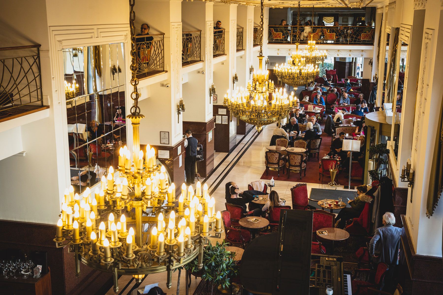 a large room with tables and chairs and chandeliers