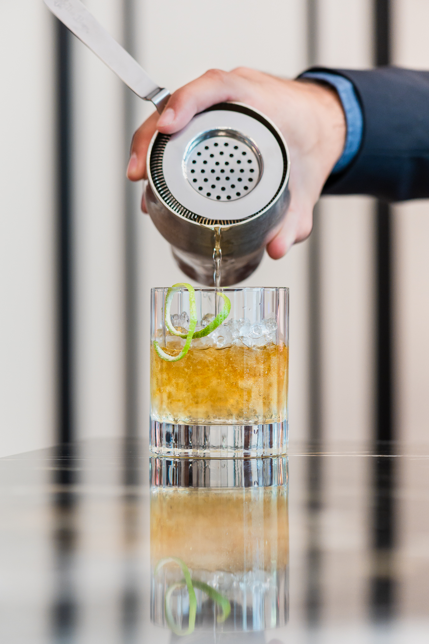 a person pouring a drink into a glass
