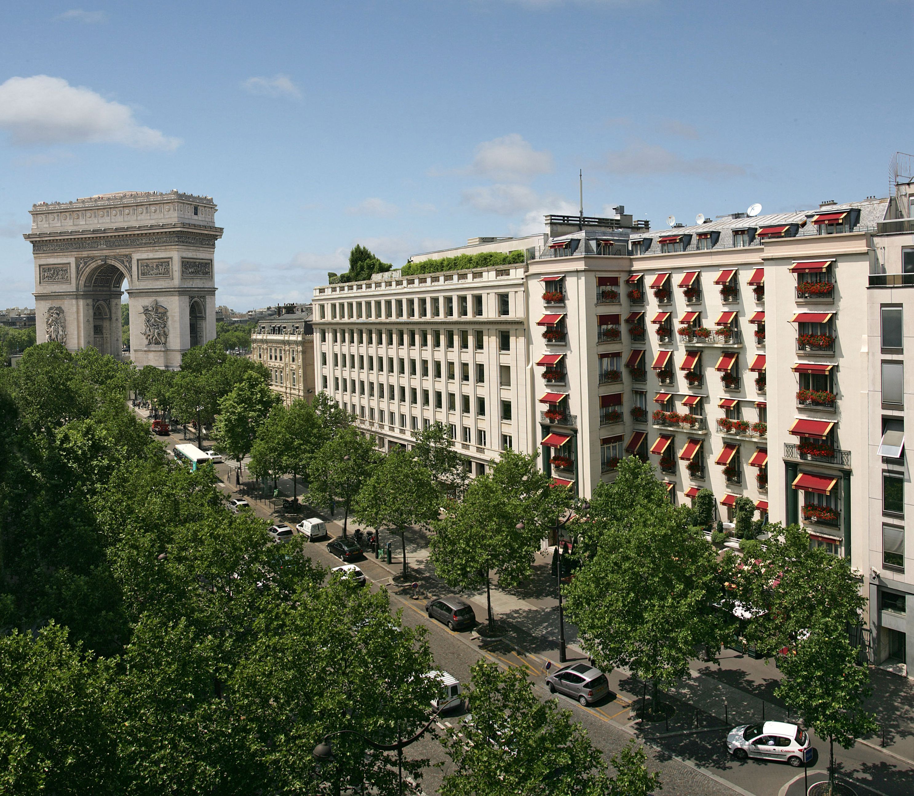 a large building with trees and a large arch