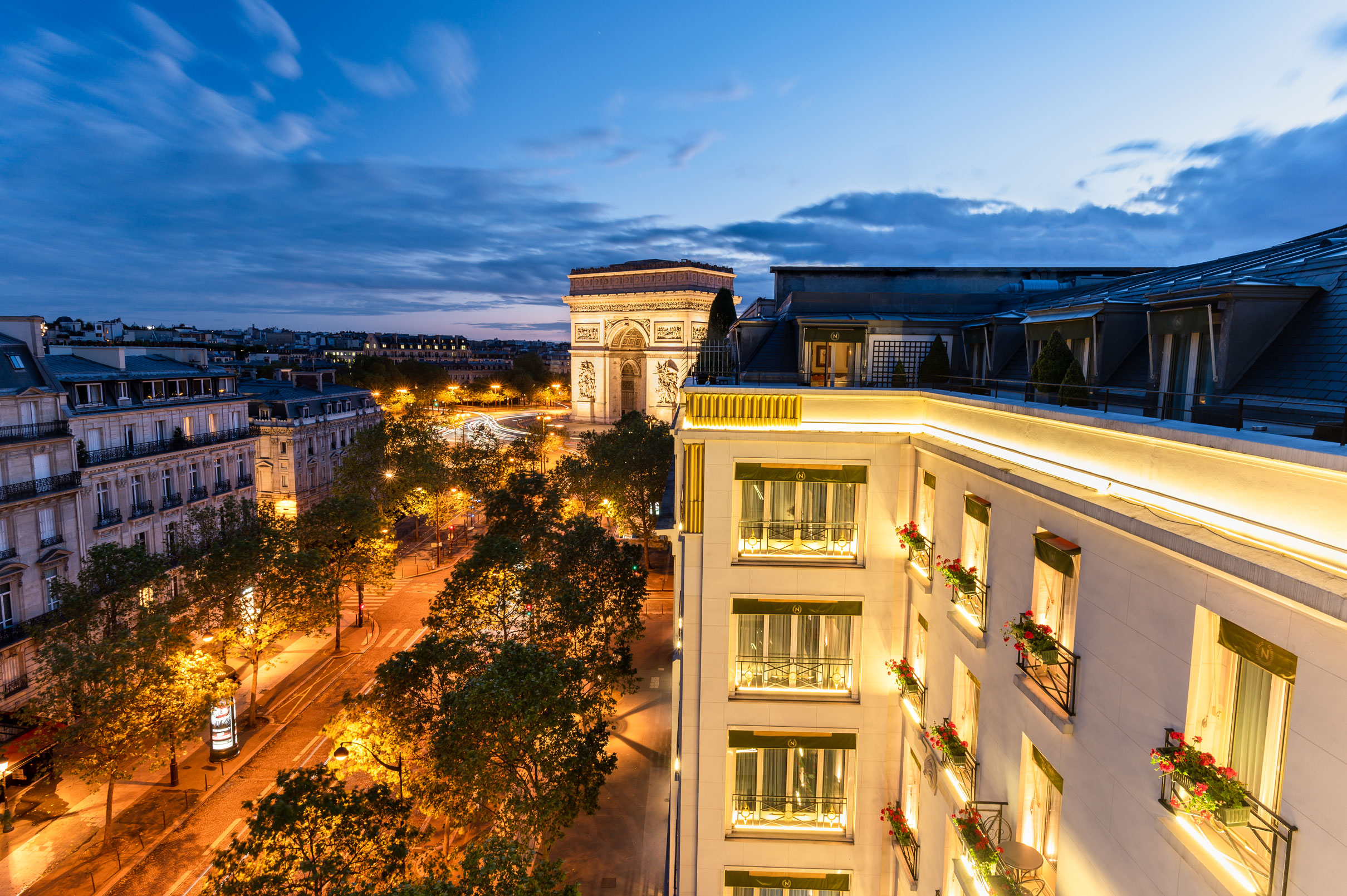 a building with lights on the windows and trees