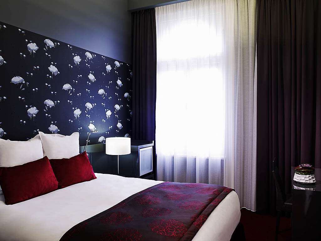 a bed with a lamp and a wallpaper