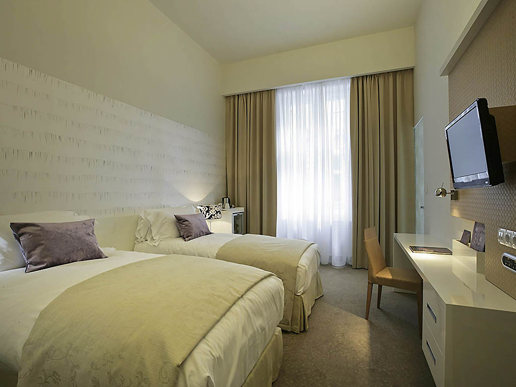 a room with two beds and a desk