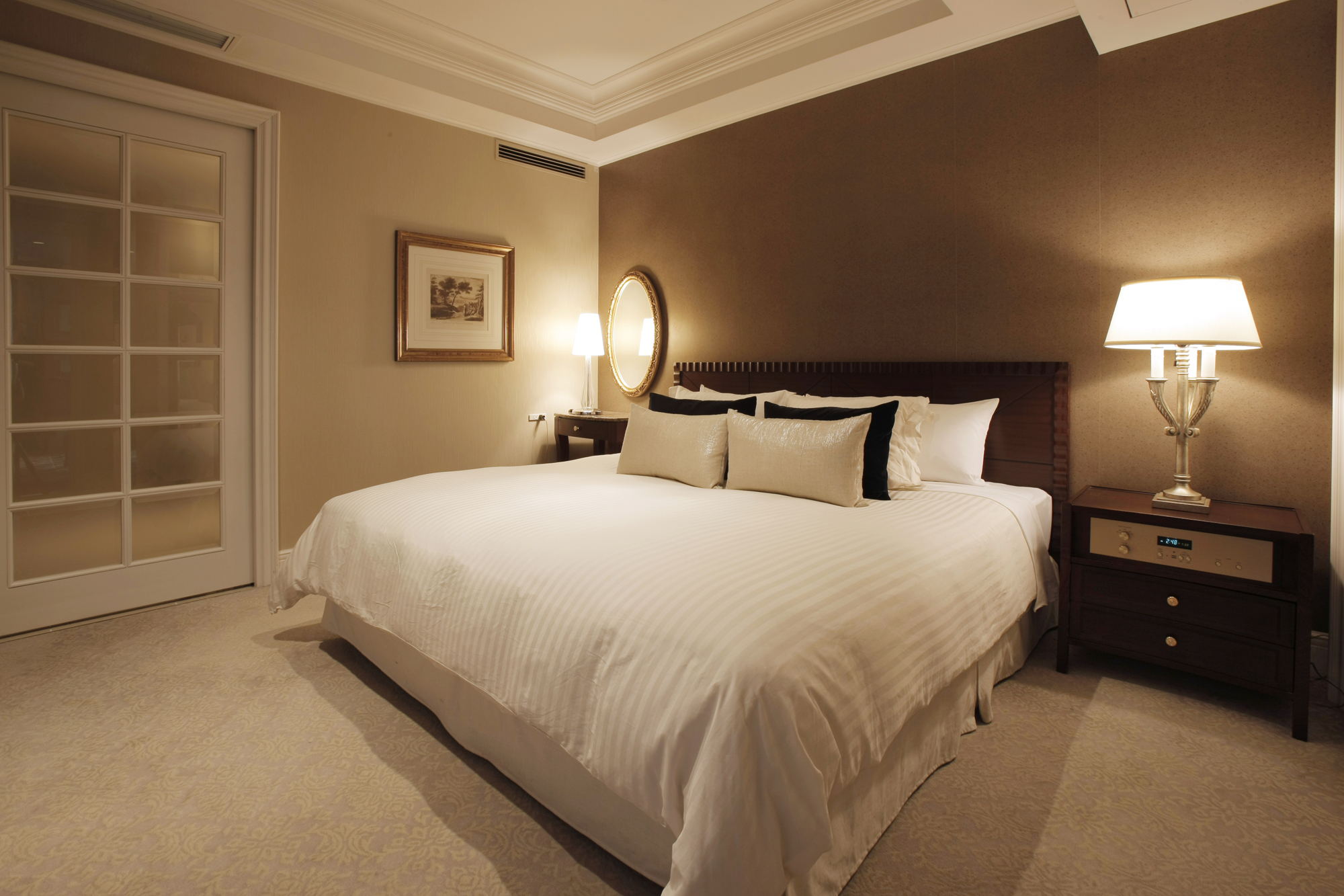 a bed with pillows and a mirror in a room