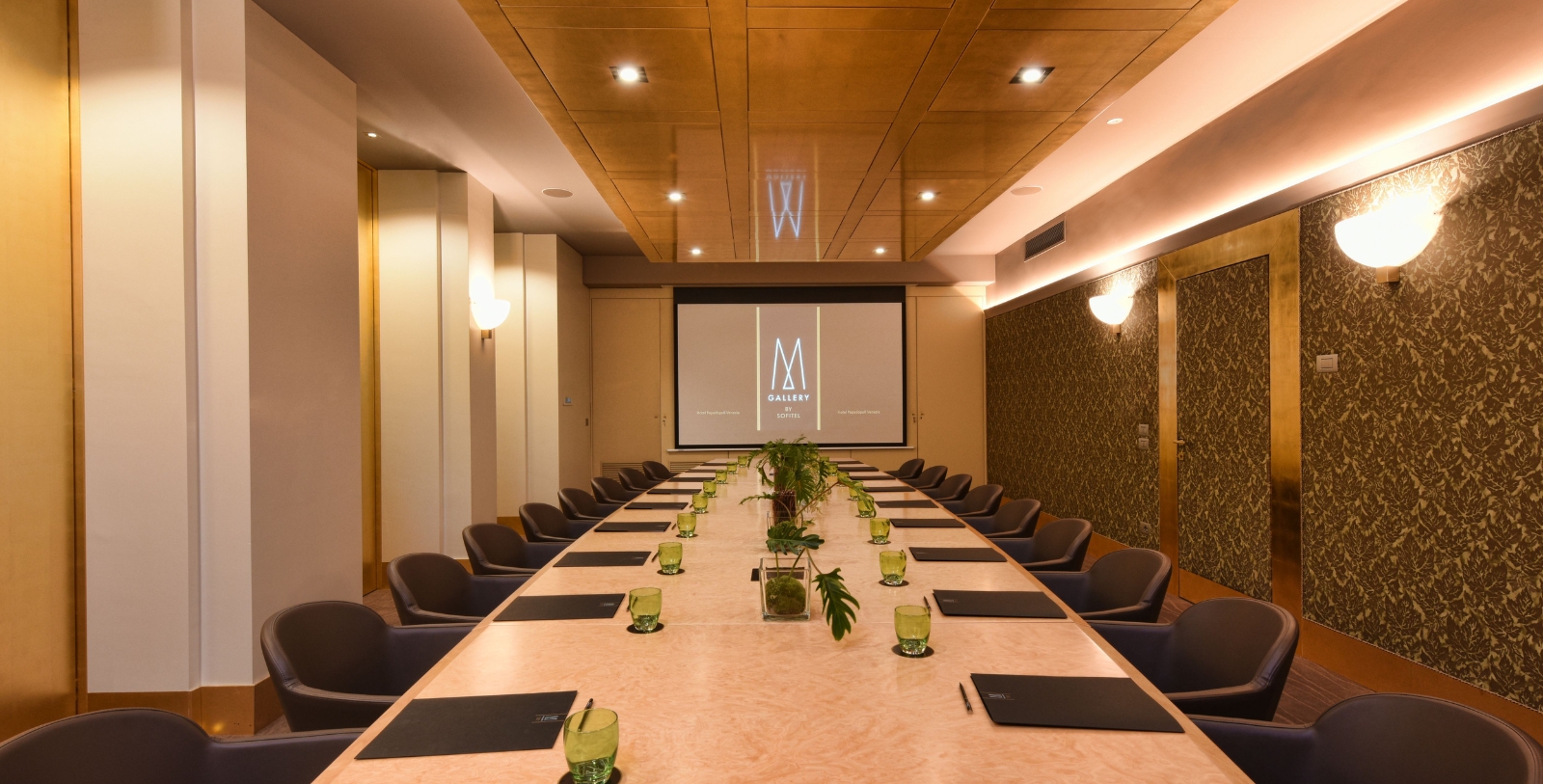 a long conference room with chairs and a projector screen