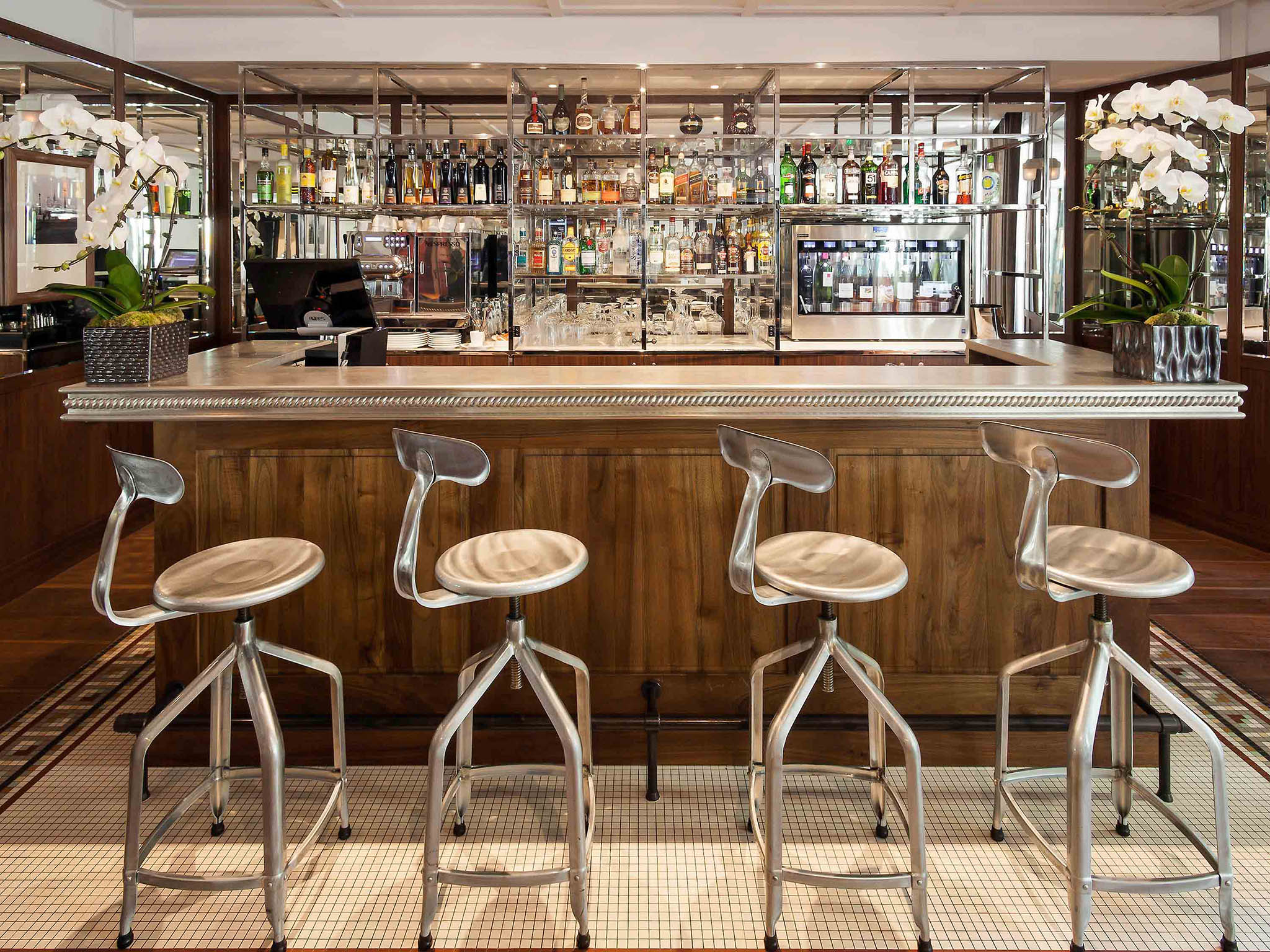 a bar with stools and bottles of alcohol