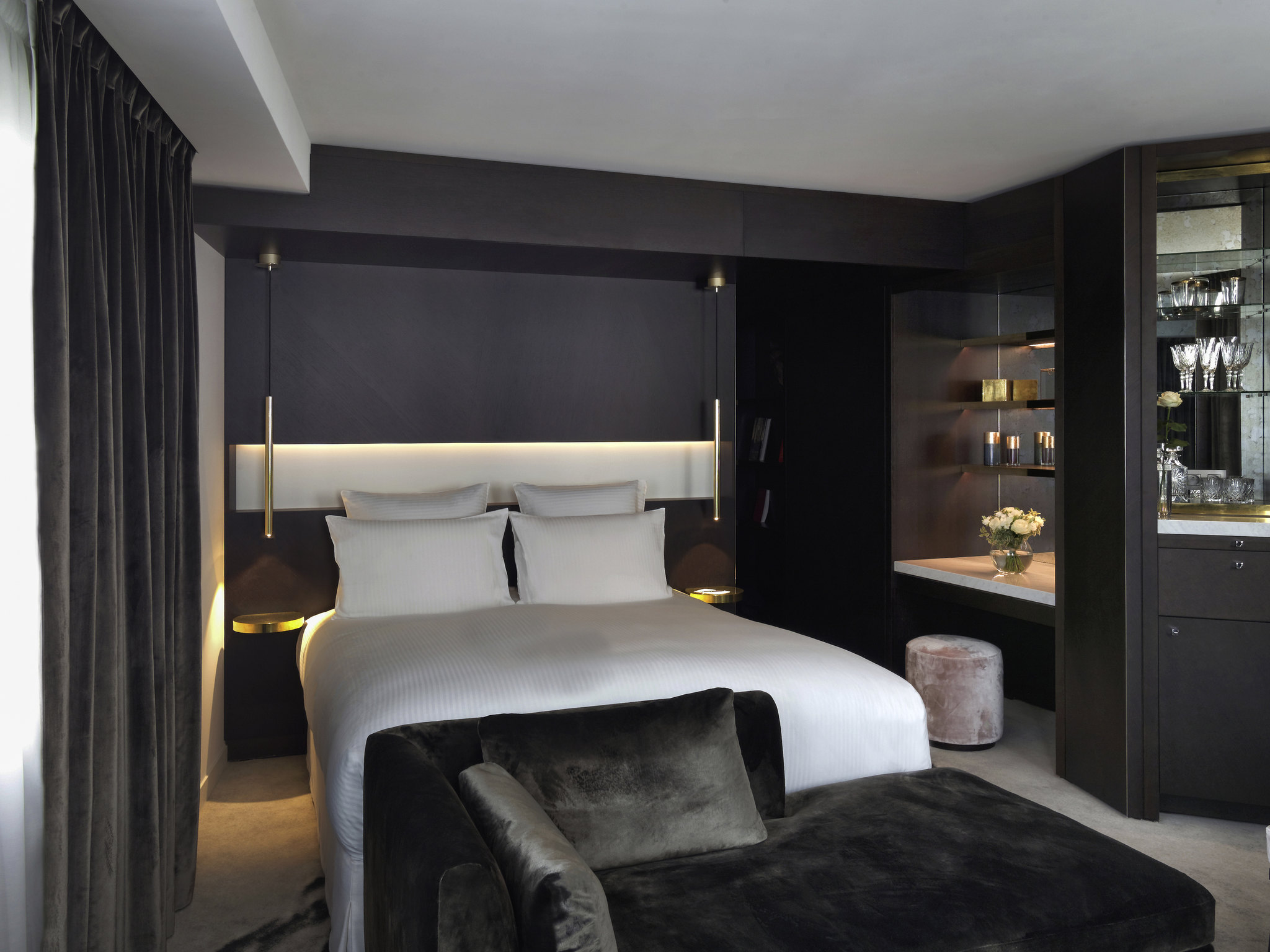 a bed with a black couch and a black chair
