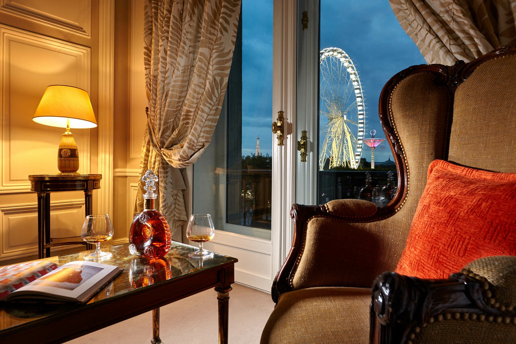a room with a chair and a table with glasses and a ferris wheel
