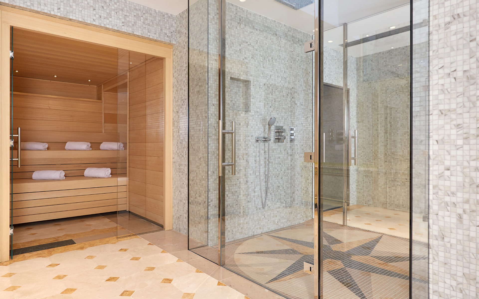 a glass shower with a wood floor and a wooden bathtub