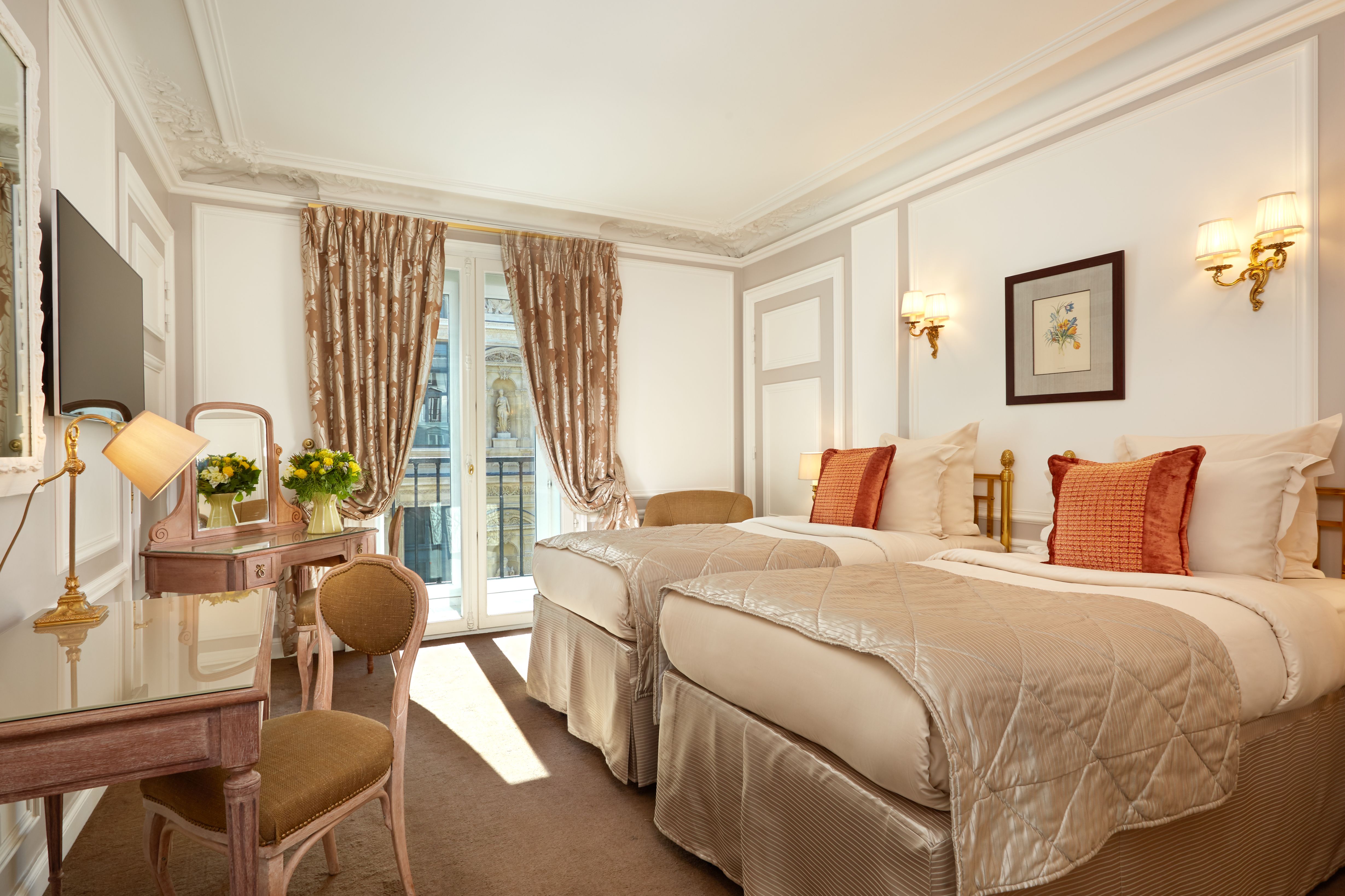 a room with two beds and a desk