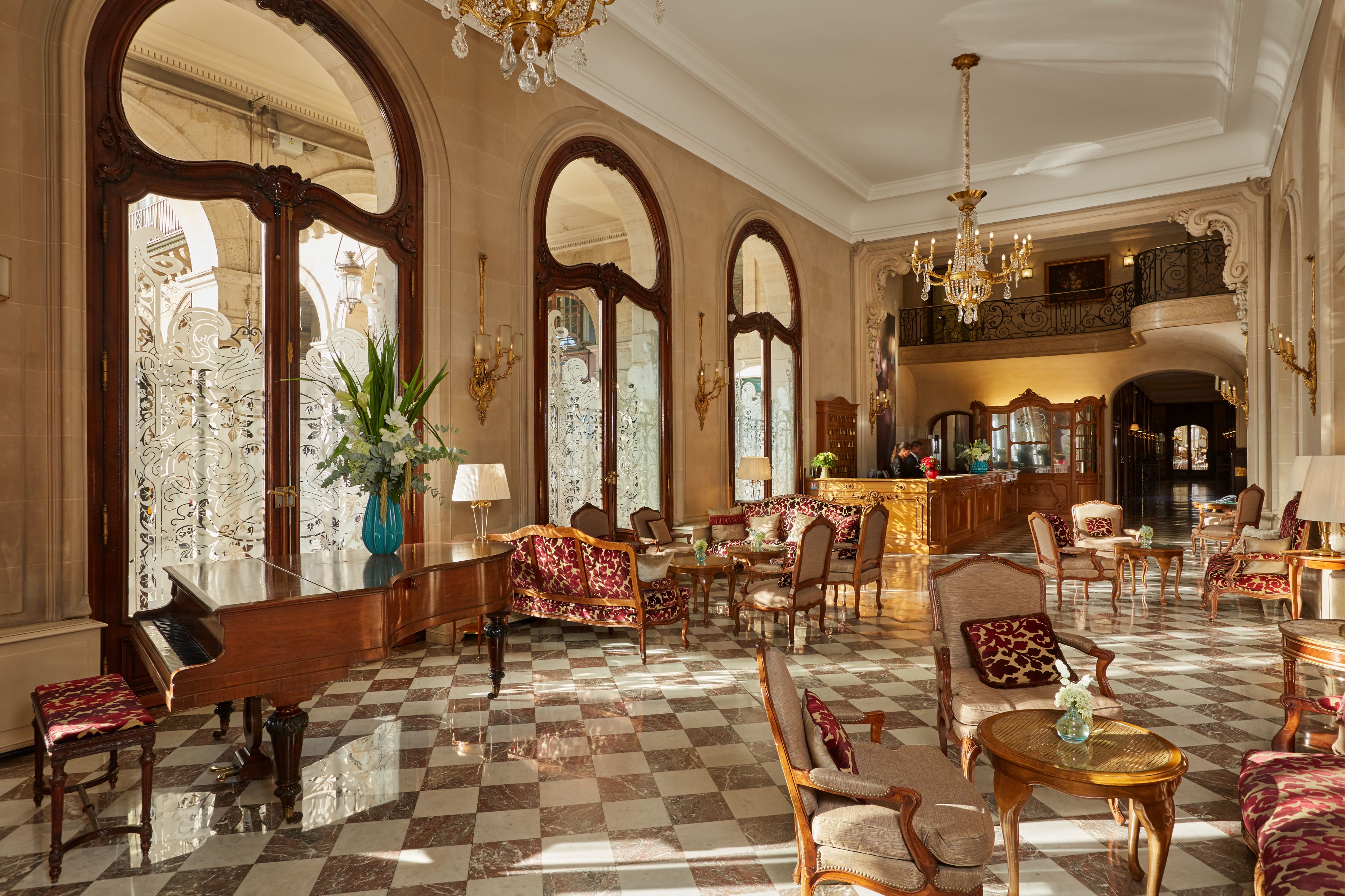 a room with a checkered floor and chandelier
